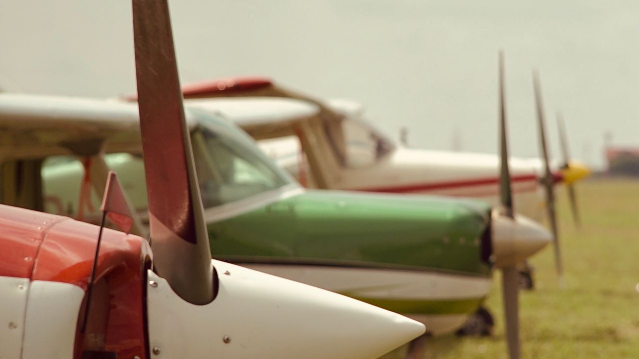 Small propeller aircraft parked on grass at a regional airfield